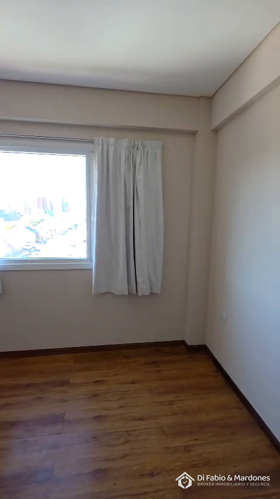 Dormitorio con ventana y piso de madera